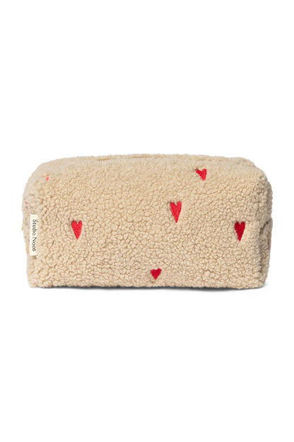 Mit Herzen bestickte Kulturtasche aus Teddystoff von Studio Noos. 