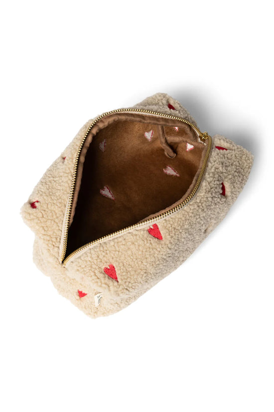 Mit Herzen bestickte Kulturtasche aus Teddystoff von Studio Noos. 