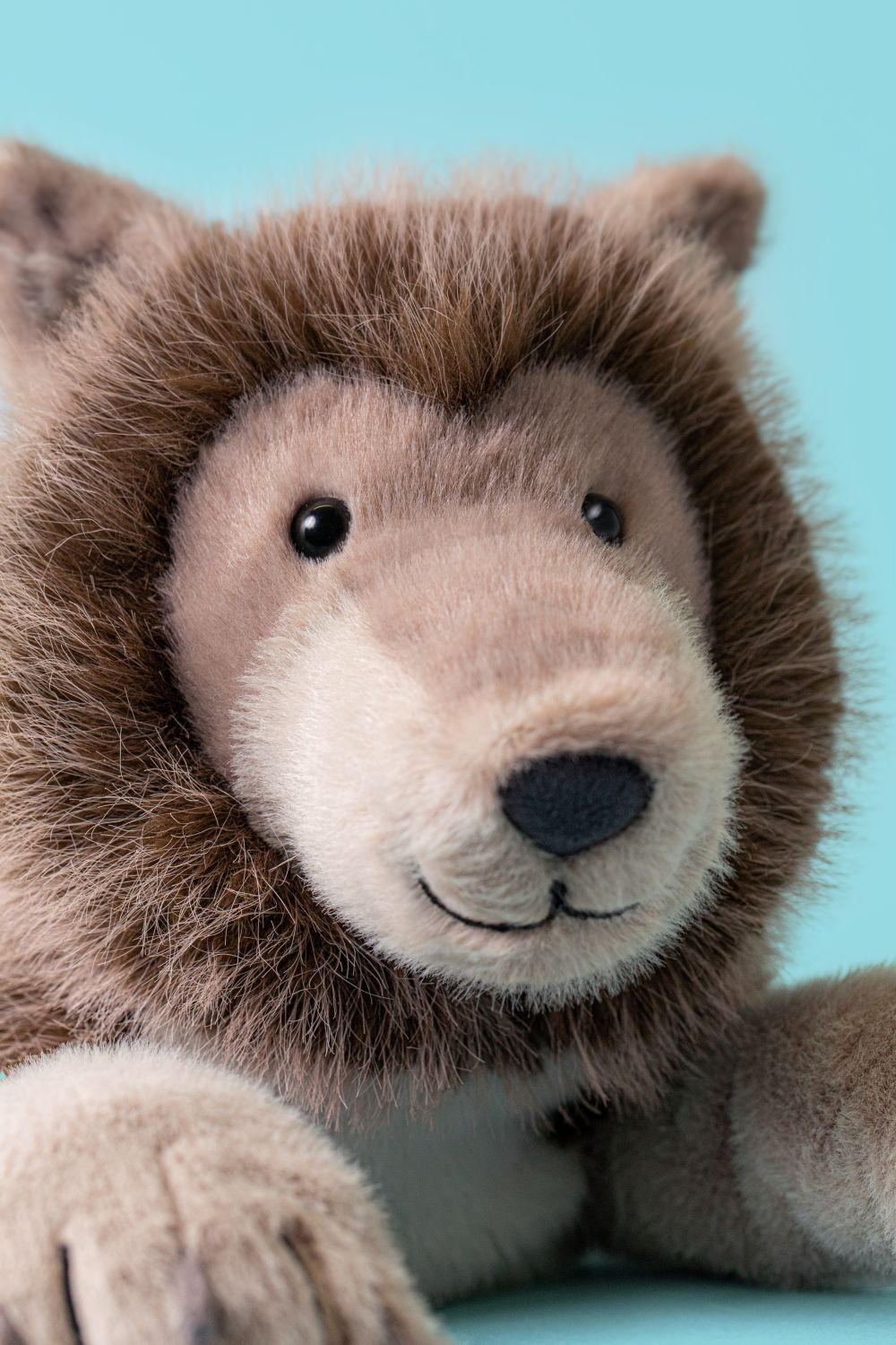 Detailansicht des freundlichen Gesichts von Jellycat Ulrich Wolf, flauschiger grauer Wolf mit großen Pfoten
