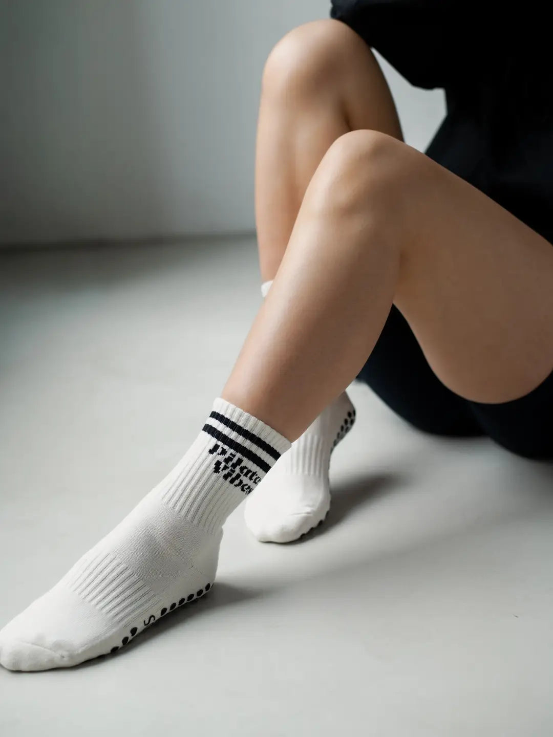 Pilates-Socken „Pilates Vibes“ von alfi STUDIOS in Weiß mit schwarzen Streifen und Schriftzug