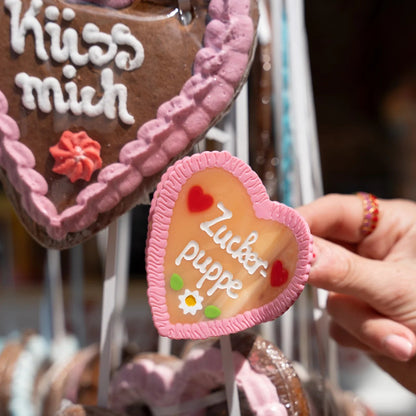 byVivi Haarklammer Lebkuchenherz Zuckerpuppe vor echten Lebkuchenherzen, pink-braune Haarspange in Herzform mit süßen Details