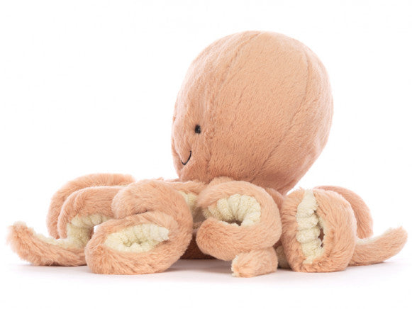 Seitenansicht: Jellycat Odell Octopus Little – rosa Kuscheltier-Oktopus mit lachendem Gesicht, helleren rosa Tentakeln und strukturierten Noppen an der Unterseite der Arme.