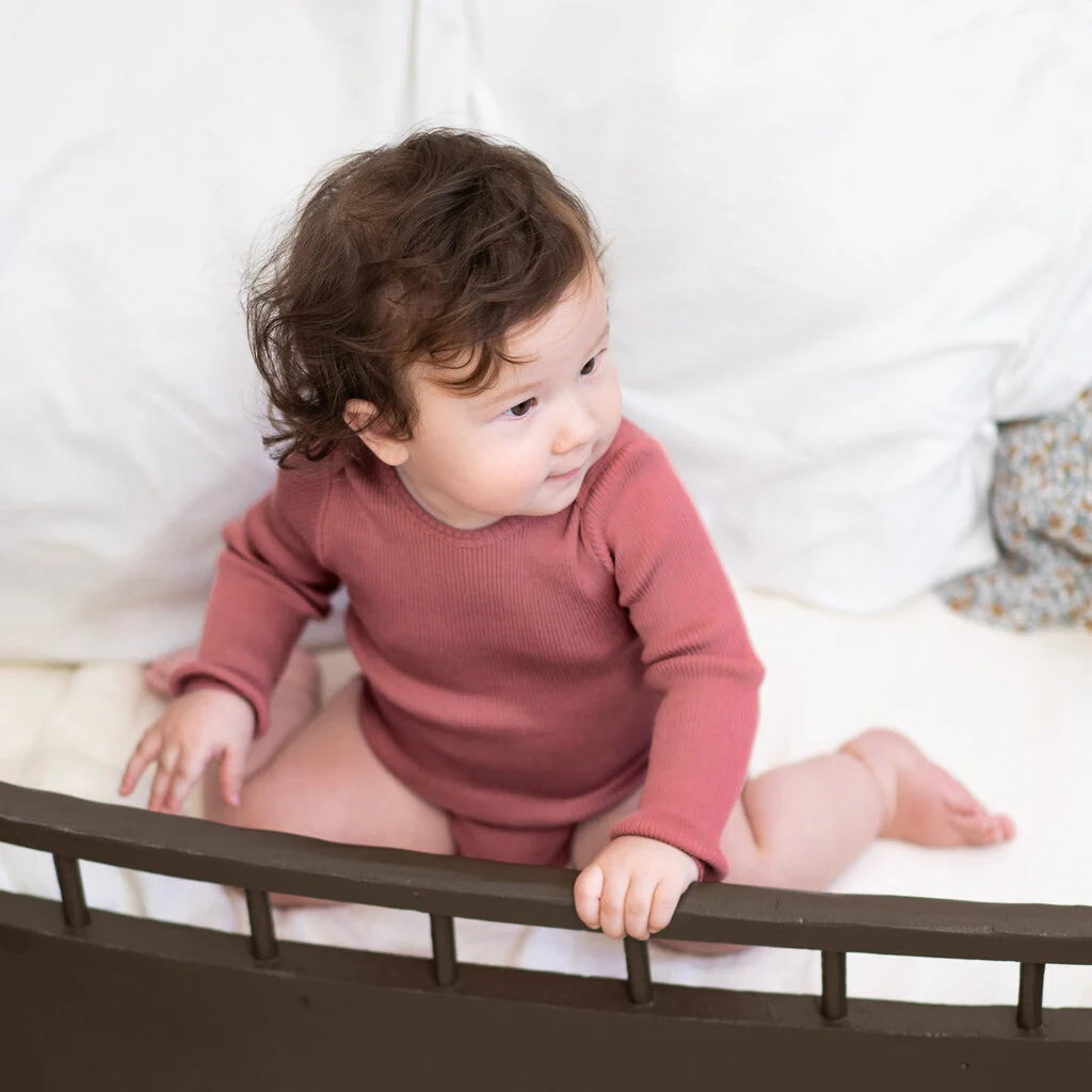 Baby trägt weichen Seidenbody Bono von minimalisma in Antique Red