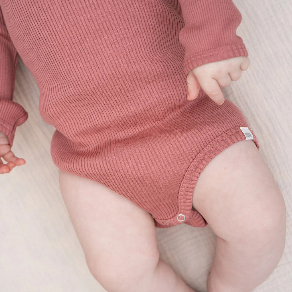 Baby trägt weichen Seidenbody Bono von minimalisma in Antique Red