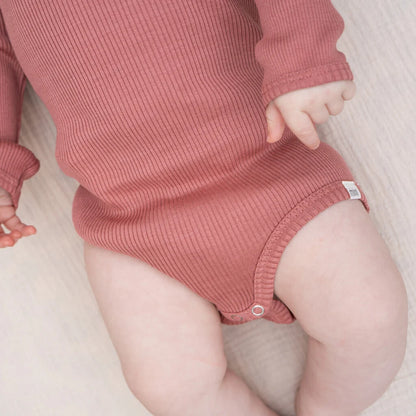 Baby trägt weichen Seidenbody Bono von minimalisma in Antique Red