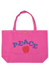 Fuchsiafarbene XL-Tragetasche mit blauem „PEACE“-Schriftzug und rotem Apfel-Print auf der Vorderseite, Rückseite ohne Motiv, aus robustem Stoff mit langen Tragehenkeln.