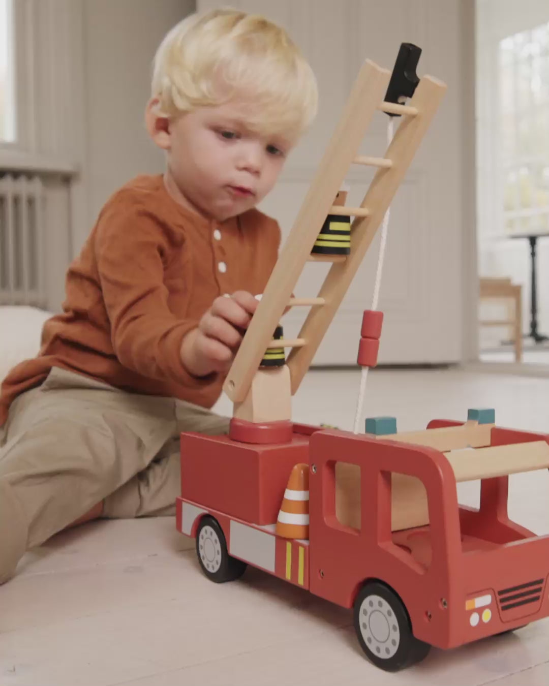 Holz-Feuerwehrauto für Kinder mit beweglichen Rädern im schlichten Design, geeignet für fantasievolles Rollenspiel ab ca. 3 Jahren.