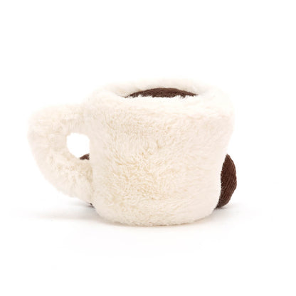 Rückansicht: Jellycat Amuseables Espresso Cup – weiße Kuscheltier-Tasse mit dunkelbraunen Füßchen, Henkel, Espresso und lachendem Gesicht mit schwarzen Knopfaugen.